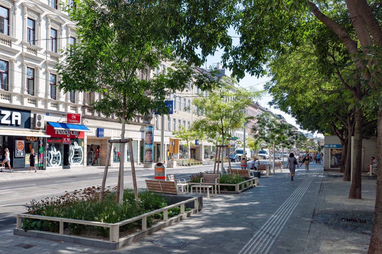 Thaliastraße 2022 Ausschnitt der Thaliastraße mit Beeten, Bäumen, Sitzgelegenheiten.
